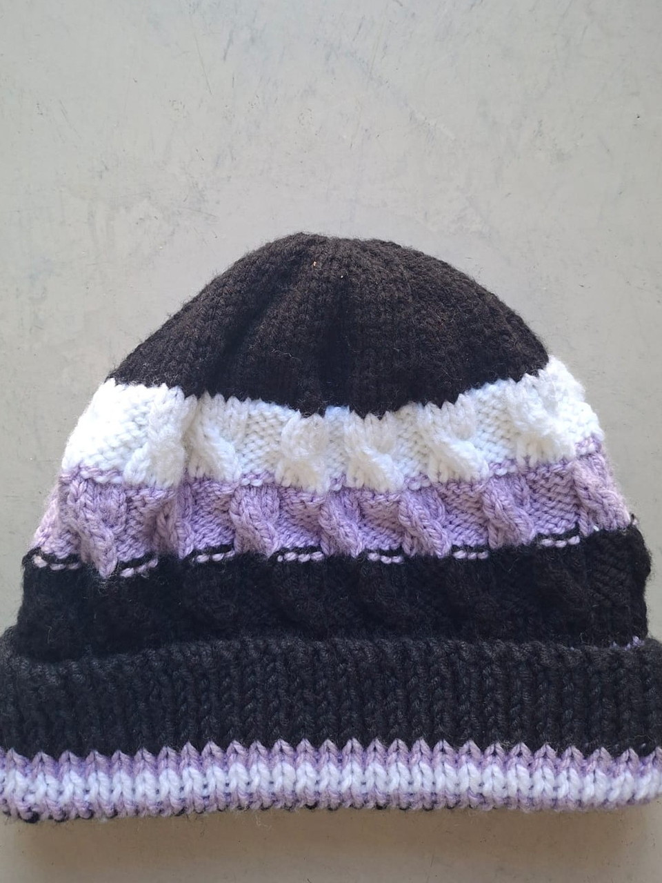 Charcoal beanie with cream and lilac cable bands, hand-knitted at Kranshoek