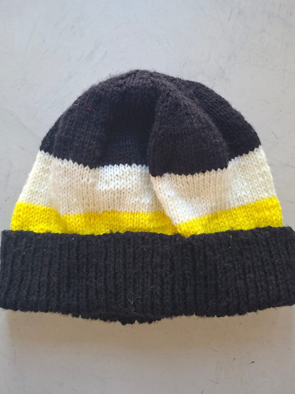 Charcoal beanie with cream and yellow bands, hand-knitted at Kranshoek