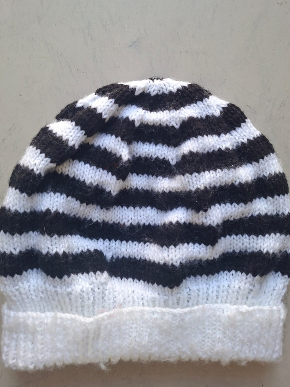 Black and white striped beanie with a white cuff, hand-knitted at Kranshoek