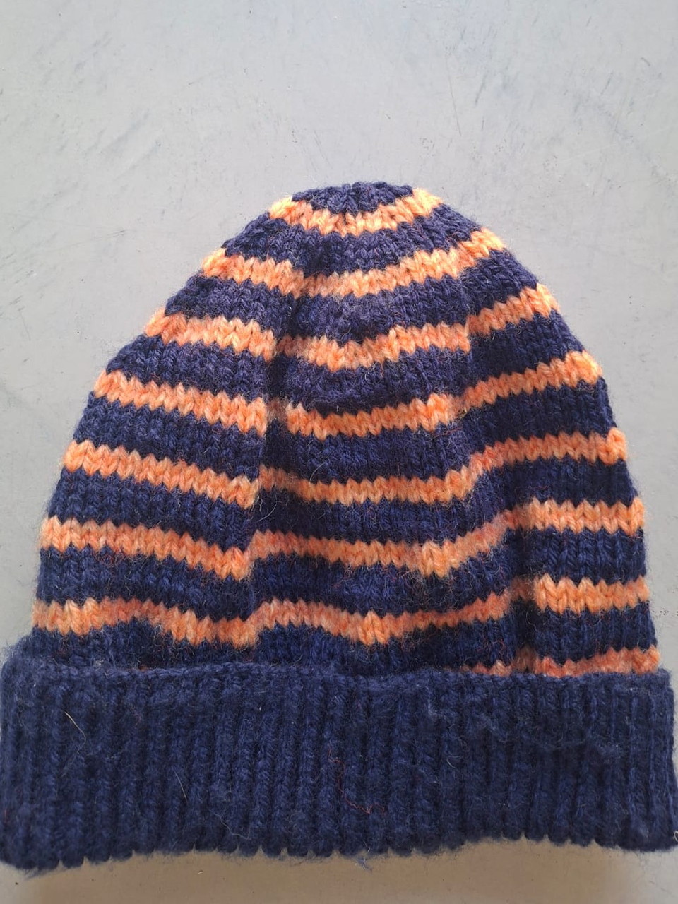Navy beanie with orange stripes, hand-knitted at Kranshoek