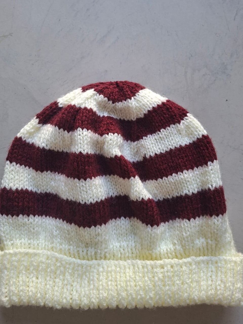 Burgundy and cream striped beanie, hand-knitted at Kranshoek