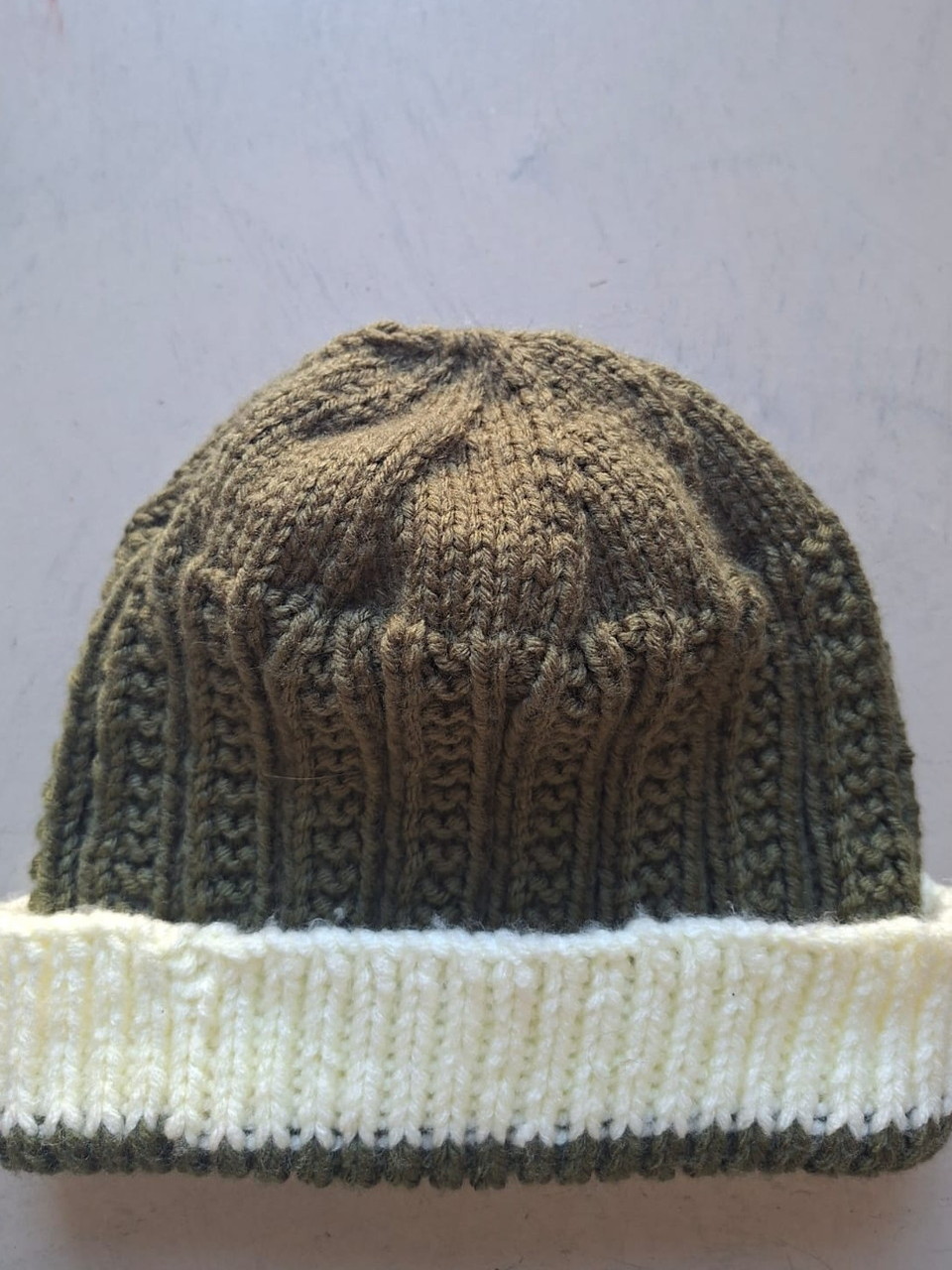Olive green cable knit beanie with a cream cuff, hand-knitted at Kranshoek
